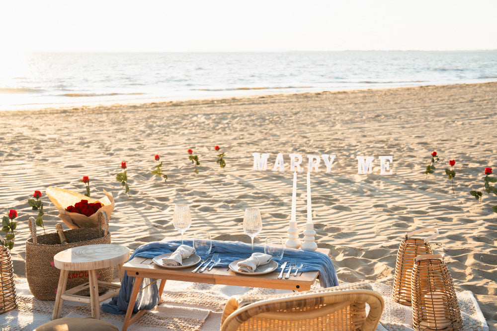 Demande en mariage à La Rochelle : mise en scène romantique, lettres “Marry Me”, roses, champagne. À ajouter à votre pique-nique TCB.